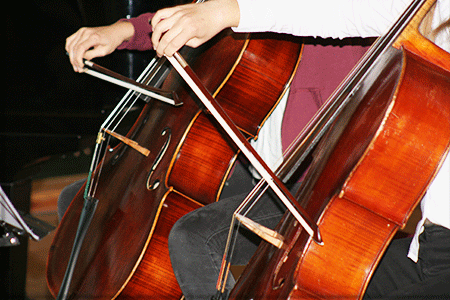 zwei Musikschüler spielen Cello