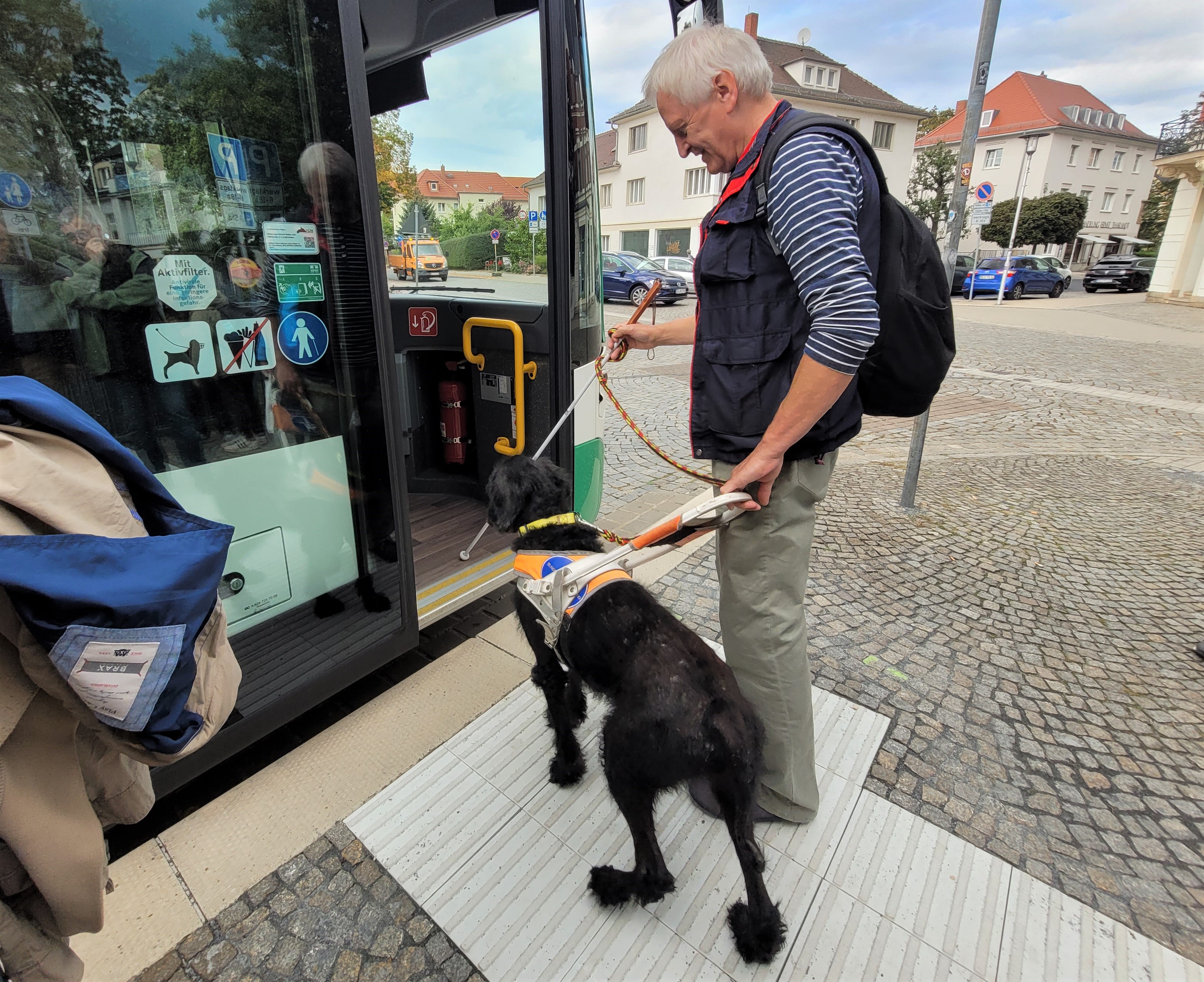 Mann mit Blindenhund beim Einsteigen in Bus