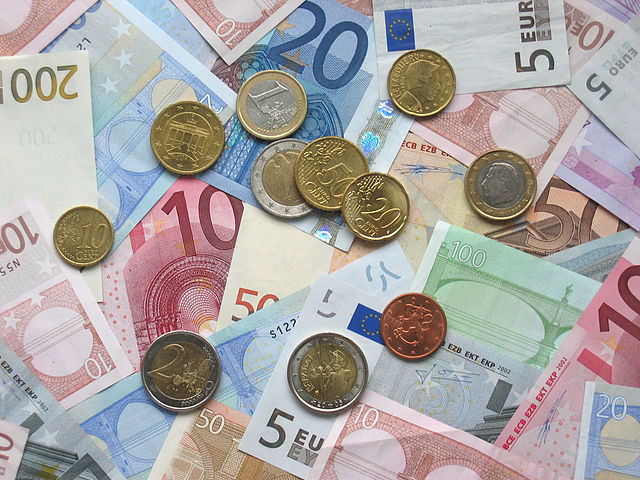 Verschiedene Euromünzen liegen auf Banknoten mit unterschiedlichem Wert